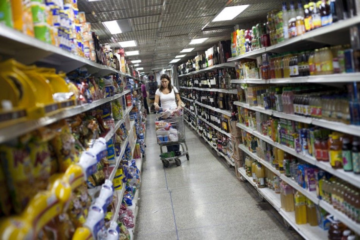 A woman looks at groceries at a supermarket in Caracas