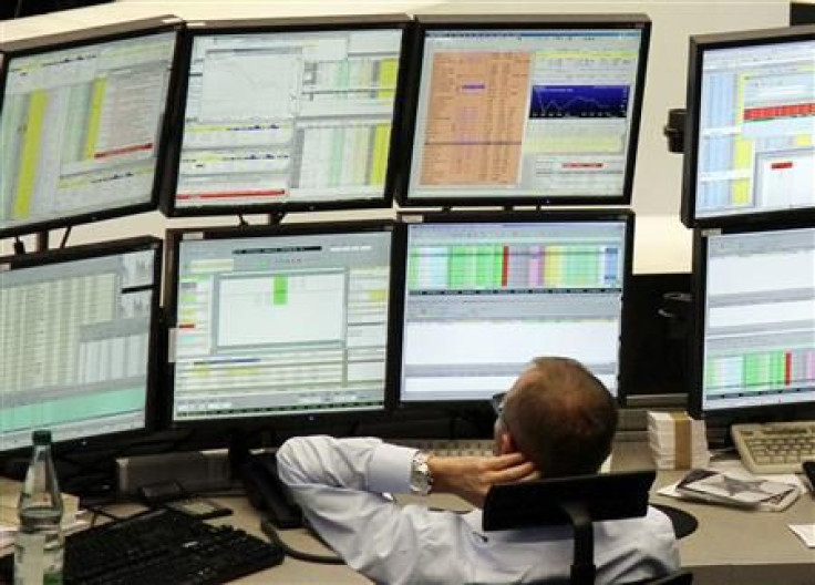 A trader is pictured at his desk in front of the DAX board at the Frankfurt stock exchange