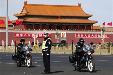 Members of the SWAT police force ride motorbikes past a policeman standing guard in Beijing