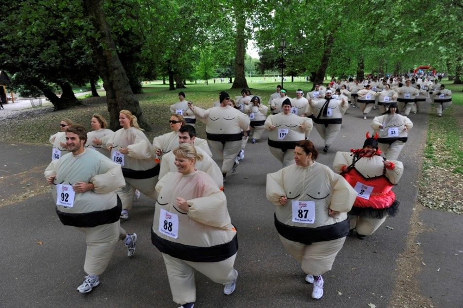Runners dressed in inflatable Sumo costumes take part in a charity 5km 3 miles run at Battersea Park in London