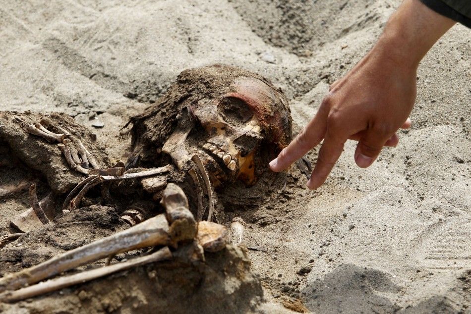Archaeologist Oscar Gabriel Prieto points to the remains of a child, part of the 42 children and 74 camelids remains unearthed that were sacrificed approximately 800 years ago in the fishing town of Huanchaquito, Trujillo