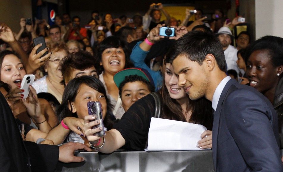 Cast member Taylor Lautner poses with a fan during the world premiere of quotAbductionquot at the Grauman039s Chinese theatre in Hollywood, California
