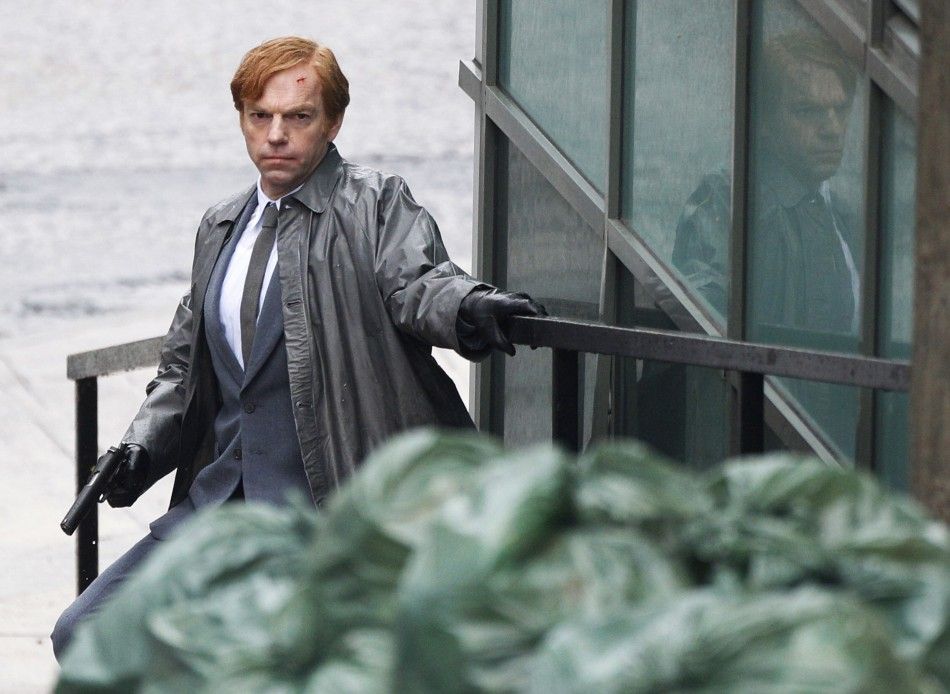 Actor Hugo Weaving crouches as he holds a gun during filming of quotCloud Atlasquot in Glasgow, Scotland