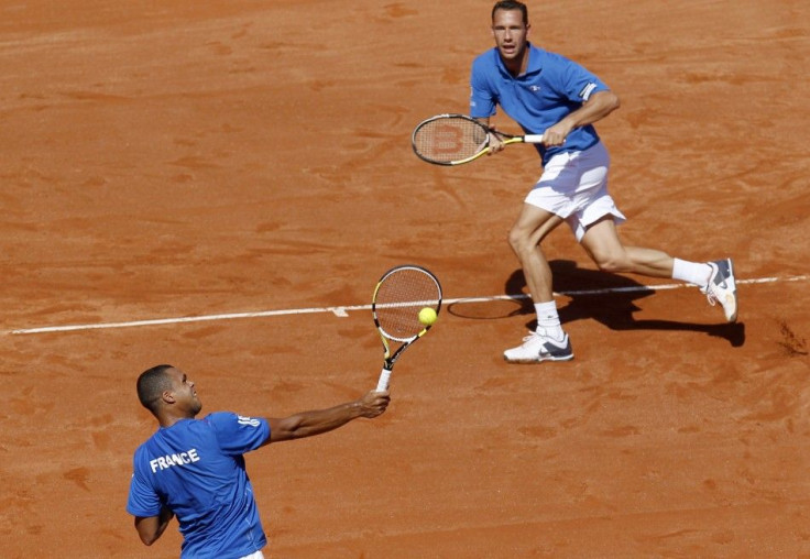 Jo-Wilfried Tsonga of France returns a shot next to team mate Michael Llodra during their doubles Davis Cup World Group semi-final rubber in Cordoba