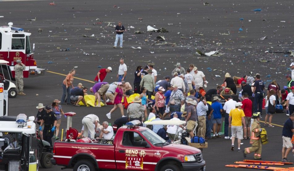 People rush to help injured spectators following the crash of a vintage World War Two P-51 Mustang fighter plane near the grandstand at the Reno Air Races in Reno Nevada