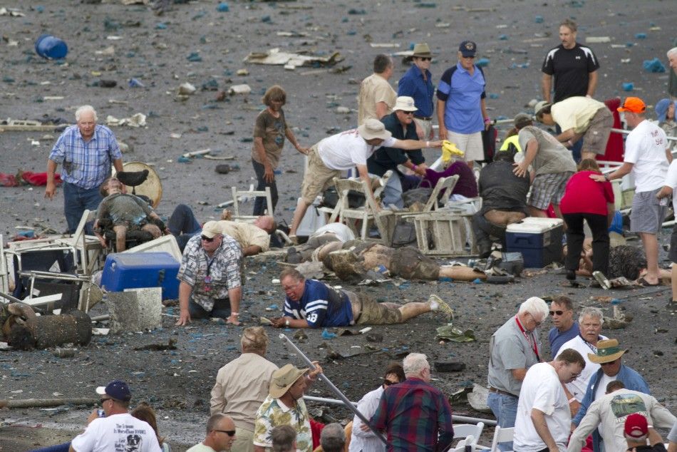 People rush to help injured spectators following the crash of a vintage World War Two P-51 Mustang fighter plane near the grandstand at the Reno Air Races in Reno Nevada