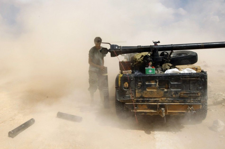 An anti-Gaddafi fighter loads a cannon near Sirte, the hometown of deposed leader Muammar Gaddafi