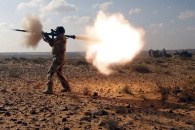 An anti-Gaddafi fighter fires a RPG against Gaddafi loyalists in a village near Sirte