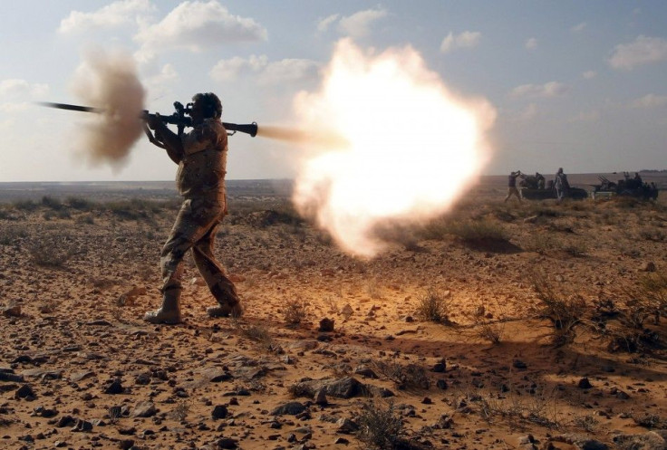 An anti-Gaddafi fighter fires a RPG against Gaddafi loyalists in a village near Sirte