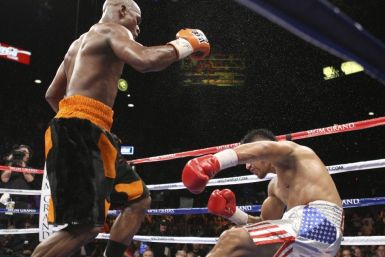 Floyd Mayweather Jr. (L) of the U.S. watches as WBC welterweight champion Victor Ortiz, also of the U.S., falls to the canvas during their title fight at the MGM Grand Garden Arena in Las Vegas, Nevada