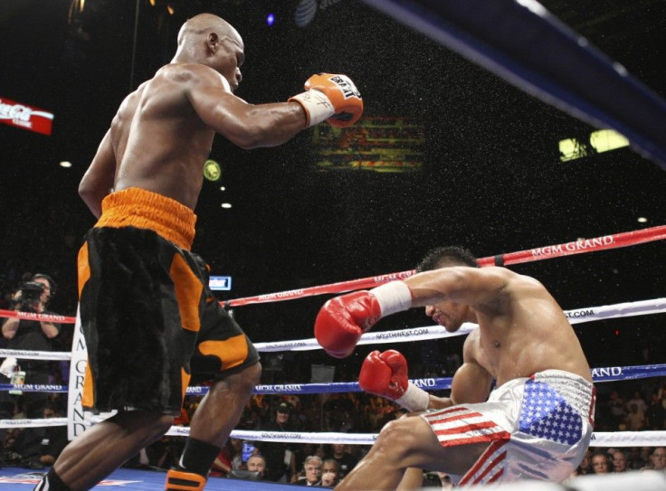 Floyd Mayweather Jr. (L) of the U.S. watches as WBC welterweight champion Victor Ortiz, also of the U.S., falls to the canvas during their title fight at the MGM Grand Garden Arena in Las Vegas, Nevada