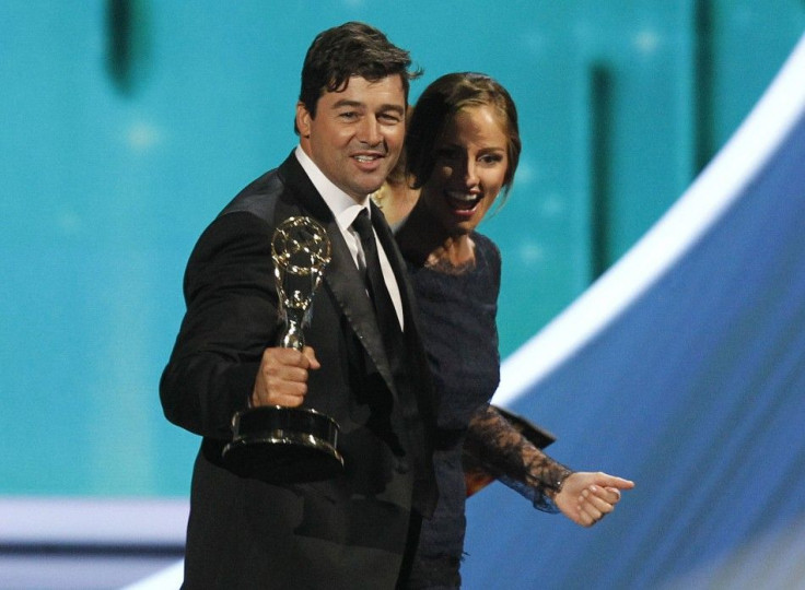 Actor Kyle Chandler walks offstage with presenter Minka Kelly after accepting outstanding lead actor in a drama series for &quot;Friday Night Lights&quot; at the 63rd Primetime Emmy Awards in Los Angeles