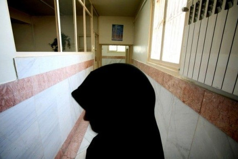 A woman prison guard stands along a corridor in Tehran's Evin prison June 13, 2006. 