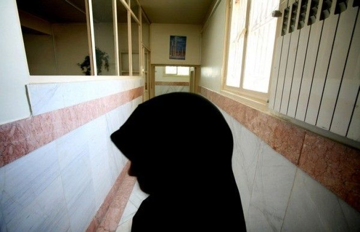 A woman prison guard stands along a corridor in Tehran's Evin prison June 13, 2006. 