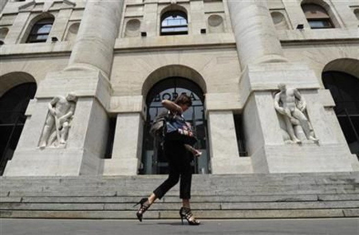 A woman walks past Milan Stock Exchange