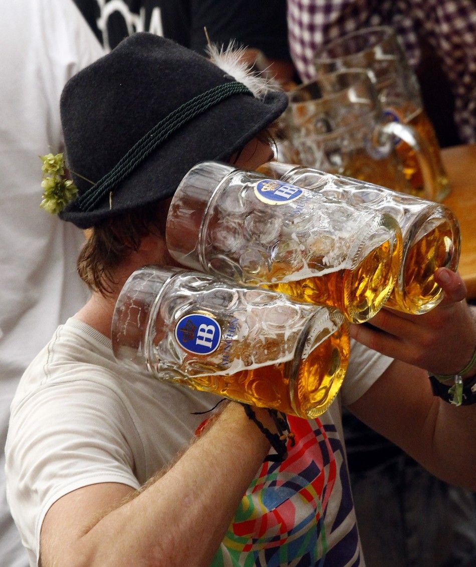 A reveller drinks beer during the first day of the Munich Oktoberfest