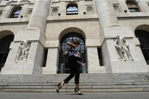 A woman walks past Milan Stock Exchange 