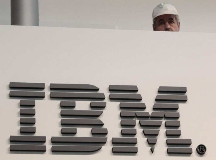 A worker is pictured behind a logo at the IBM stand on the CeBIT computer fair in Hanover