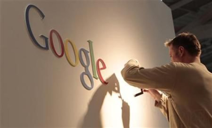 Man works on Google logo at exhibition stand at CeBIT computer fair in Hanover