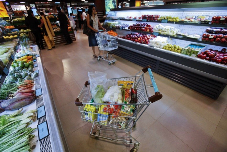 A trolley laden with fresh and processed food sits parked in an aisle as customers shop at a supermarket in Mumbai May 30, 2011.