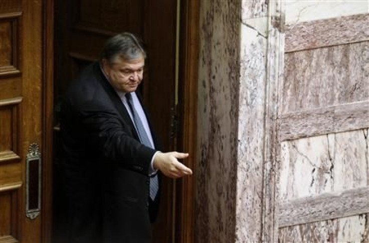 Greece&#039;s Finance Minister Venizelos waits for documents to be handed to him as he leaves a parliament session in Athens