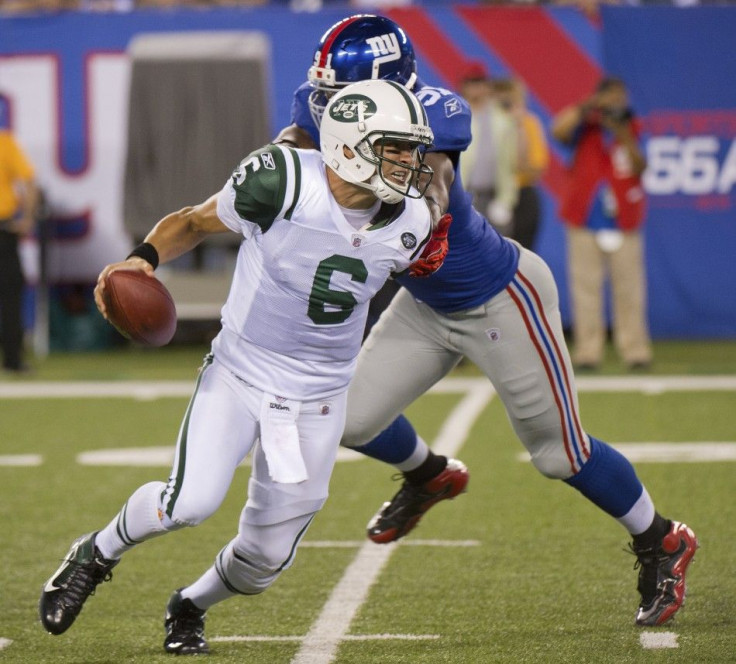 New York Jets Mark Sanchez breaks away from New York Giants Justin Tuck in East Rutherford