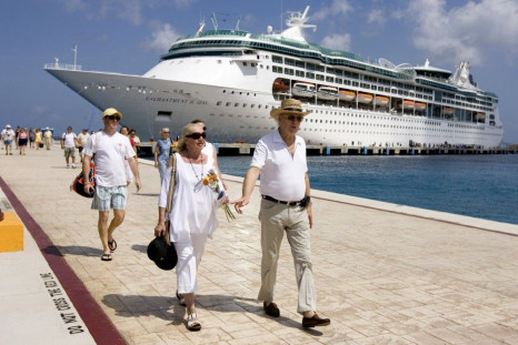 Tourists walk beside Royal Caribbean's cruise ship ?Enchantment of the Seas? after they arrive in Cozumel