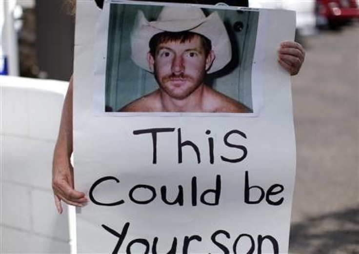 A supporter of Kelly Thomas, a 37-year-old homeless man who died in the custody of Fullerton county police, carries a sign with his picture outside the District Attorney&#039;s office in Santa Ana, California