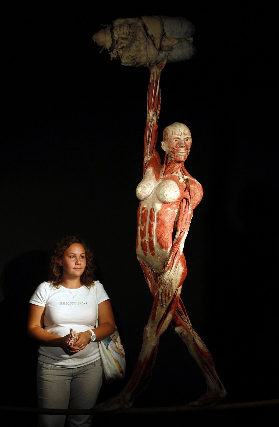 A visitor L looks at a plastinated human body during the exhibition quotBody Worldsquot by Gunther von Hagen in Rome 