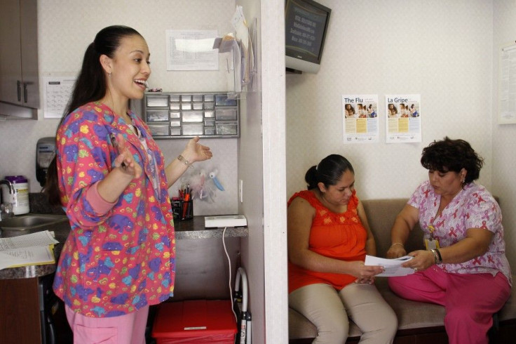 Nurse Margarita Montijo (L) calls on the next patient as nurse Mariantonieta Delgado (R) goes over paper work with a woman receiving a prenatal exam at the Maternity Outreach Mobile in Phoenix