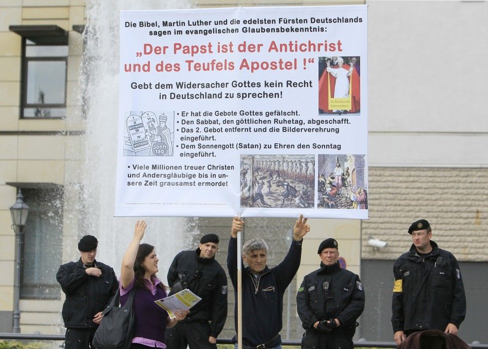 Demonstrator opposing the visit of Pope Benedict XVI holds signboard during a protest at Potsdamer Platz in Berlin