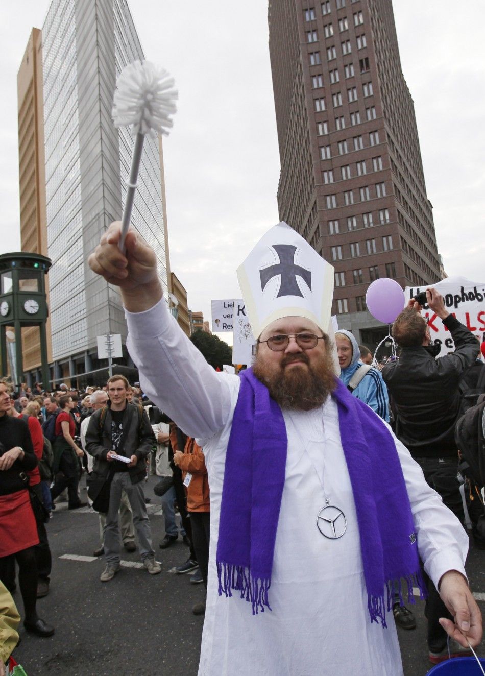 A demonstrator opposing the visit of Pope Benedict XVI waves a toilet bowl brush during a protest at Potsdamer Platz in Berlin 