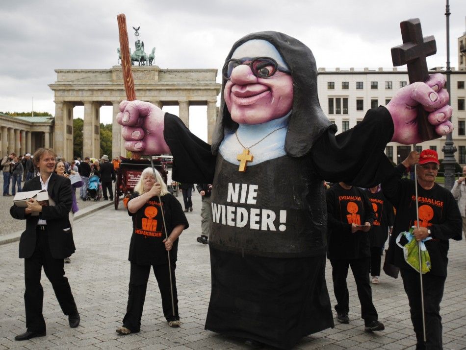 A demonstrator opposing the visit of Pope Benedict XVI wears a caricature of a Catholic nun with a slogan reading Never Again, during a protest in front of the Brandenburg Gate in Berlin 