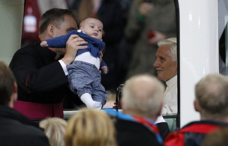 Pope Benedict XVI blesses baby from Pope Mobile as he arrives to lead Holy Eucharist celebration at Olympic Stadium in Berlin