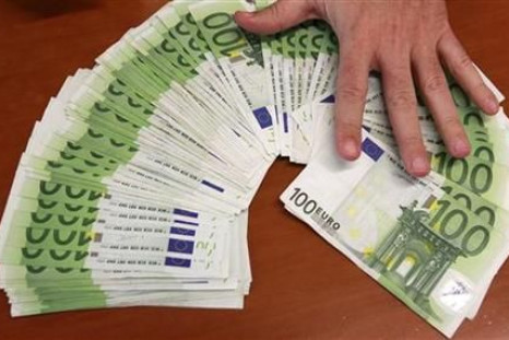 A bank employee spreads out euro bank notes in Madrid
