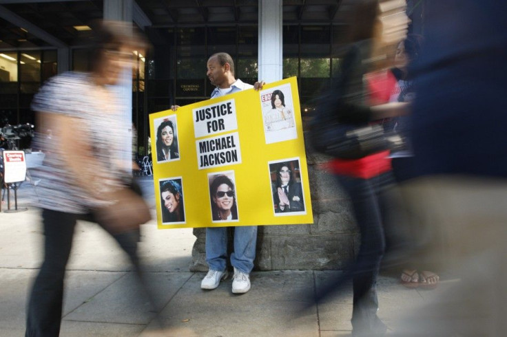 An activist holds a poster with photos of late pop star Michael Jackson outside the Criminal Courts building in Los Angeles