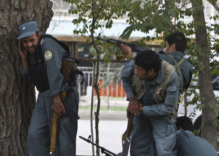 Afghan policemen fire towards a building which the Taliban insurgents took over during an attack near the U.S. embassy in Kabul