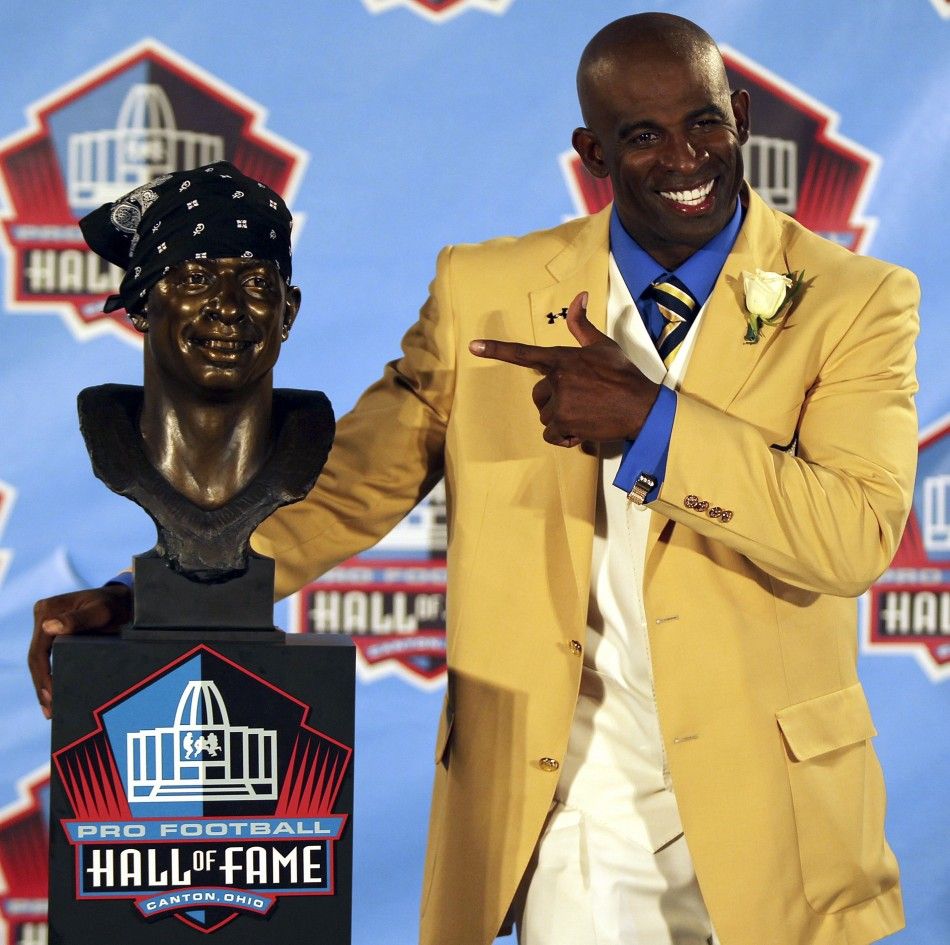 Former Dallas Cowboy Sanders posses with his bust during his induction into the NFL Pro Football Hall of Fame in Canton