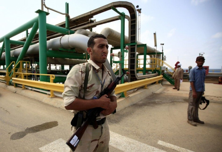 An anti-Gaddafi fighter stands guard at the Mellitah Oil and Gas complex during a handover ceremony in Mellitah