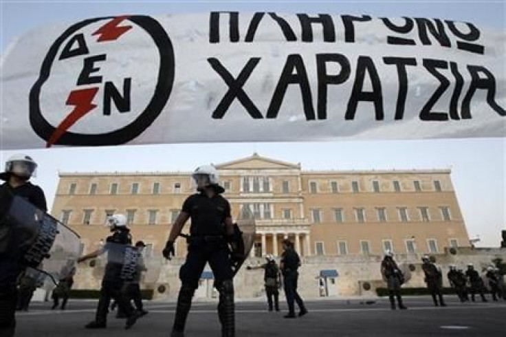 Riot police stand in front of the parliament during a rally in Athens