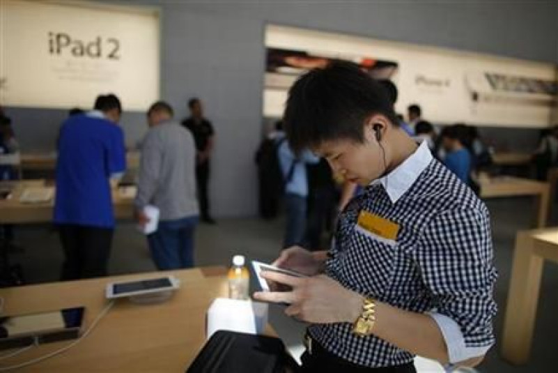 A man looks at an Apple iPad 2 at the company's new store in Nanjing Road, Shanghai