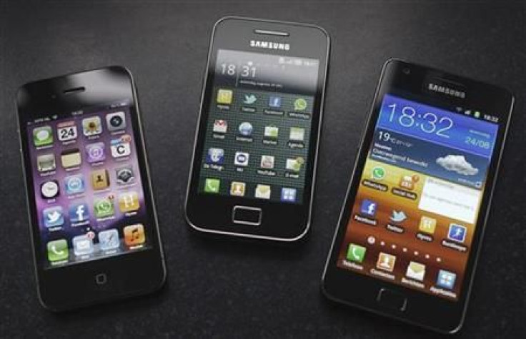 A Samsung S II and Samsung Ace smartphones are seen next to an Apple iPhone 4 in Houten