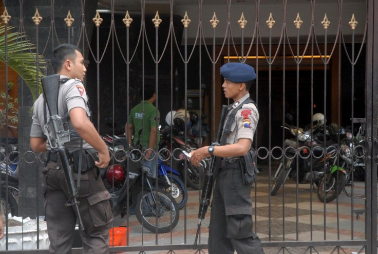 Policemen stand guard in front of the church gate in Solo