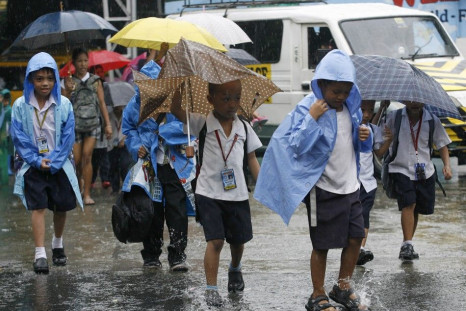 Students walk home in the rain after the suspension of classes due to rainfall from Typhoon Nesat in Quezon City