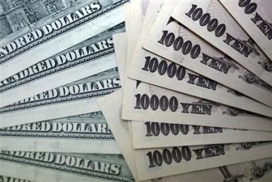 File photo of Japanese 10,000 yen notes spread out next to U.S. dollar bills at an Interbank Inc. money exchange office in Tokyo