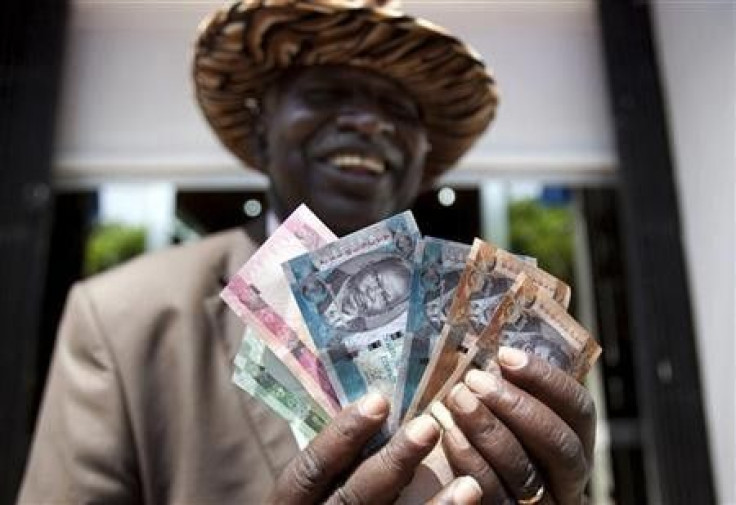 A man from South Sudan displays new currency notes outside the Central Bank of South Sudan in Juba