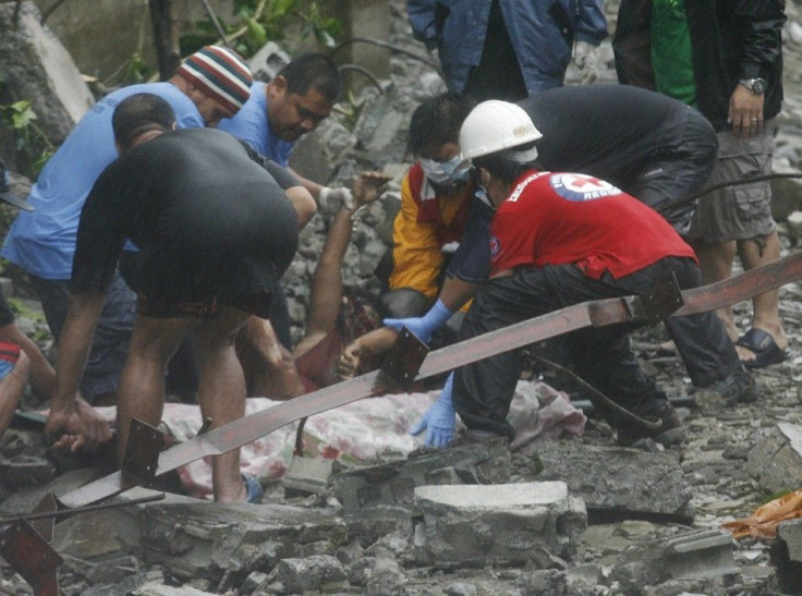 Rescuers recover a body beneath the rubble after strong winds brought by Typhoon Nesat knocked down a wall killing four residents in Valenzuela City 27/09/2011