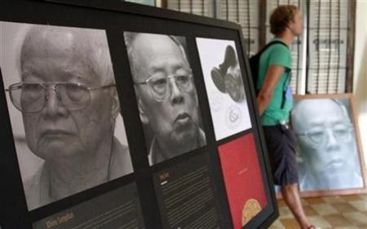 A tourist walks past portraits of former Khmer Rouge President Khieu Samphan (L), 78, and ex-Foreign Minister Ieng Sary, 84, at Toul Sleng genocide museum in Phnom Penh