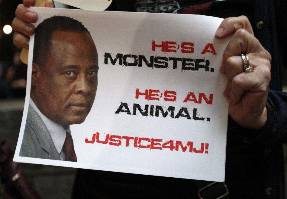 A demonstrator holds a placard during the opening day of Dr. Conrad Murray039s trial in the death of pop star Michael Jackson in Los Angeles