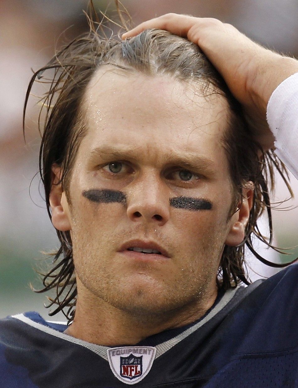 New England Patriots quarterback Tom Brady prepares to put on his helmet before running onto the field in the second quarter against the New York Jets during their NFL football game in East Rutherford, New Jersey, September 19, 2010. 